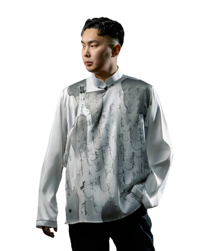 A stylish Mongolian men's shirt made of white silk, adorned with black traditional calligraphy patterns, blending heritage with contemporary style.