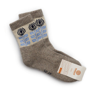 Natural beige wool socks with a black and blue flower pattern on the cuffs, made from Mongolian wool for winter comfort and style