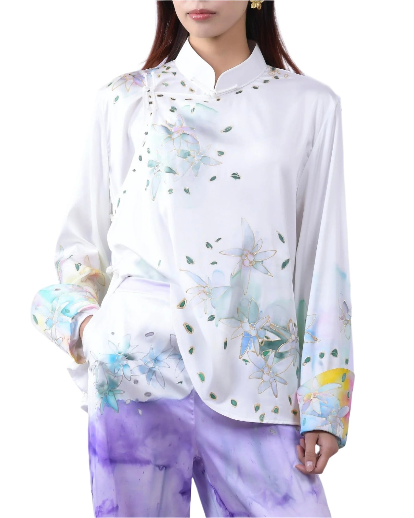 A white silk blouse with vibrant hand-painted edelweiss designs on the shoulder and cuffs, blending artistic charm with timeless elegance.