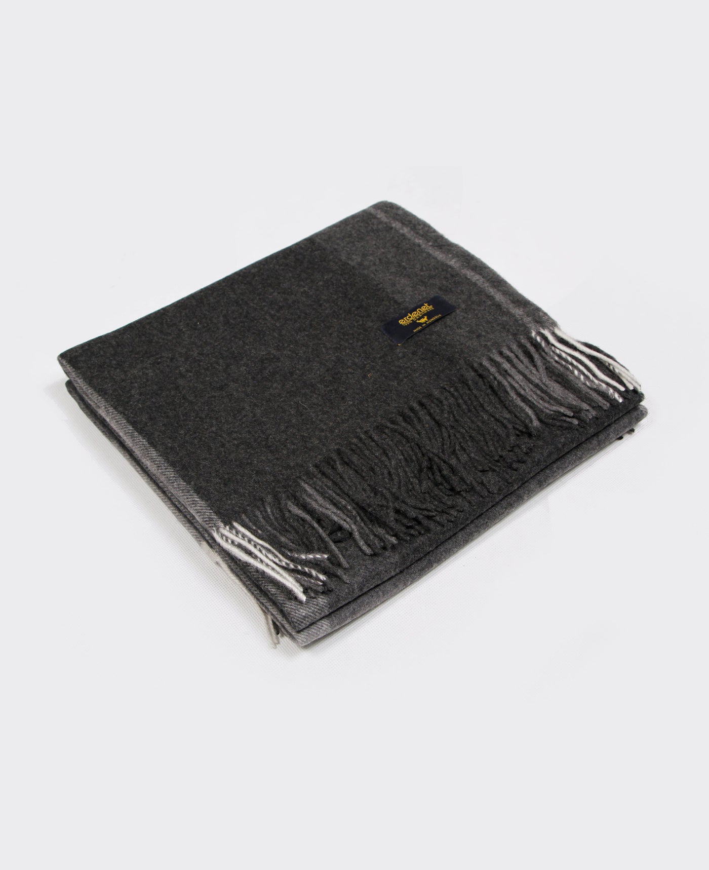 A luxurious dark gray Mongolian cashmere plaid with elegant fringe details, made from 100% sustainable cashmere.