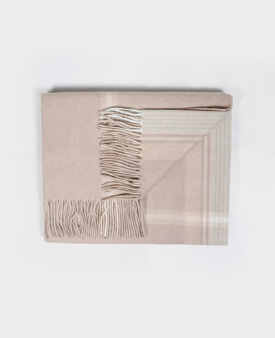 A light beige Mongolian cashmere plaid with fringe detailing, made from 100% sustainable and soft cashmere.