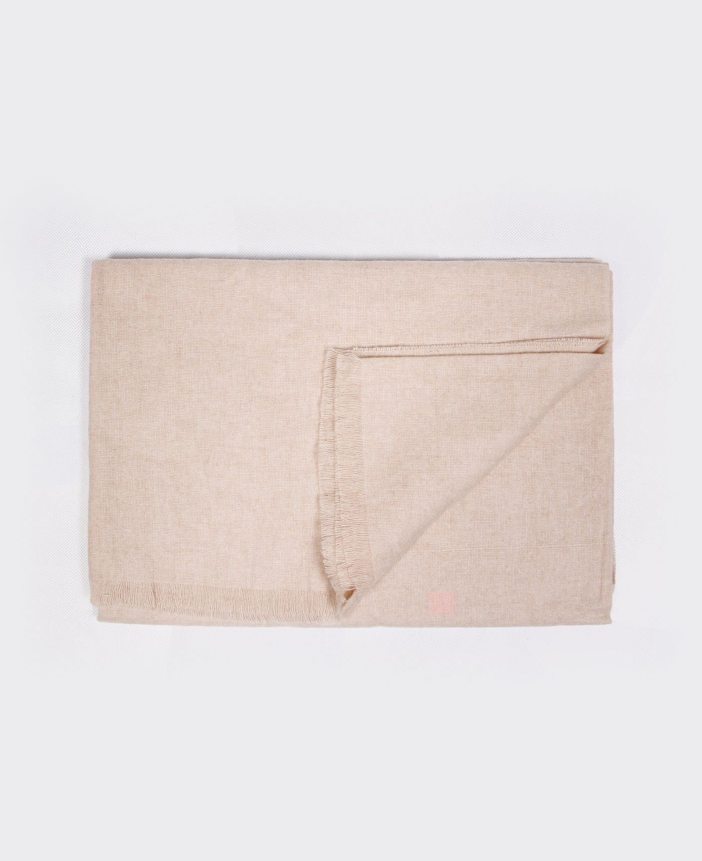 Beige cashmere plaid with a rolled edge, sustainably made in Mongolia, offering softness, warmth, and style.

