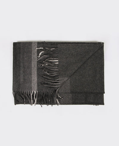 Dark grey cashmere with a light grey line and fringed edges, sustainably sourced from Mongolia, offering warmth and comfort.