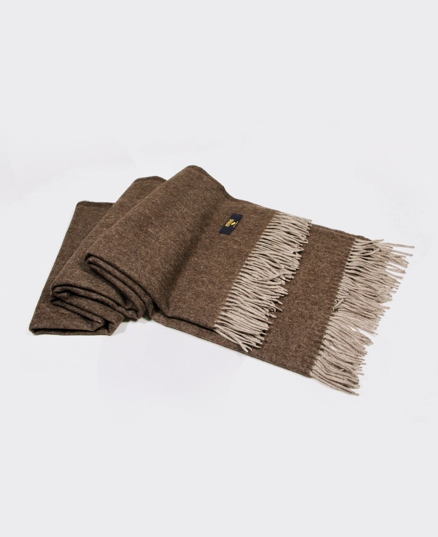 Brown yak wool plaid with fringed edges, sustainably sourced from Mongolia, offering warmth and comfort