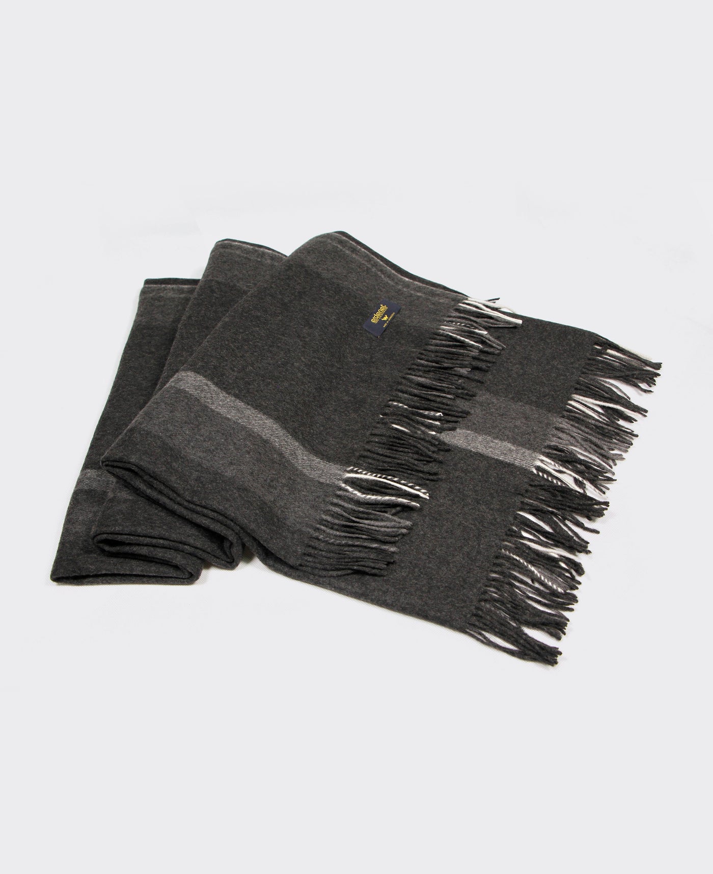 Dark grey cashmere plaid with a light grey line and fringed edges, sustainably sourced from Mongolia, offering warmth and comfort.