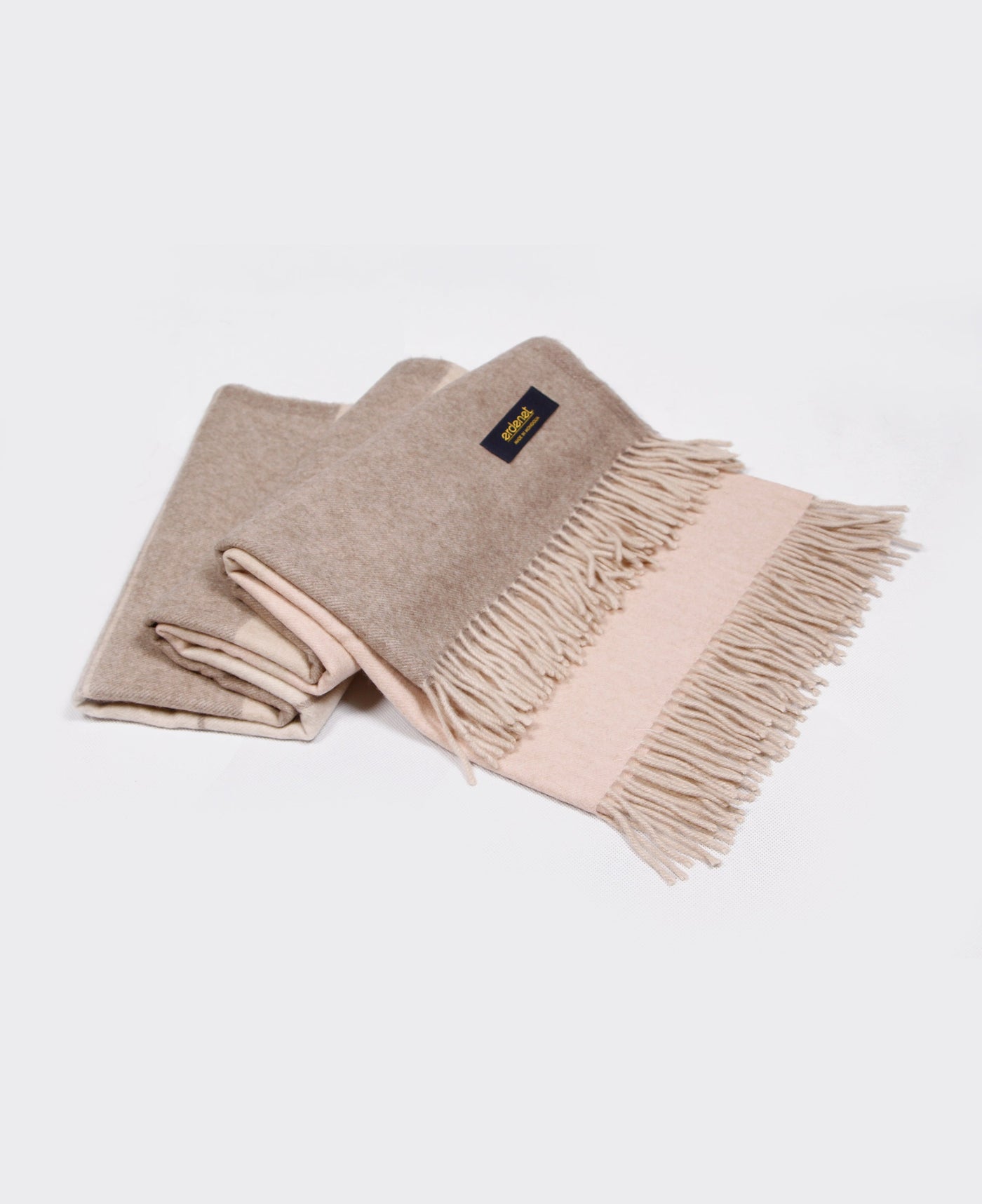 Beige and light pink dual tone cashmere plaid with fringed edges, made in Mongolia, offering luxurious softness and warmth.