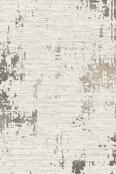 A carpet featuring an abstract design with distressed patterns in shades of grey, beige, and white, set against a textured background.